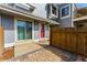 Charming townhouse entrance with a bright red door, brick pavers, and a wooden fence at 2557 S Dover St # 30, Lakewood, CO 80227