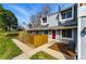 Inviting townhouse featuring a red door, wooden privacy fence, and well-maintained landscaping at 2557 S Dover St # 30, Lakewood, CO 80227