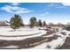 View of parking lot featuring parking spaces, mature trees, and clear blue skies at 2557 S Dover St # 30, Lakewood, CO 80227