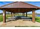 Open picnic shelter with picnic tables, grills, and concrete slab overlooking a lake at 2557 S Dover St # 30, Lakewood, CO 80227