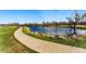 Scenic view of pond with paved walking path, lush green grass, and mature trees at 2557 S Dover St # 30, Lakewood, CO 80227