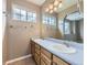 Bright bathroom featuring a double sink vanity, framed mirror, and natural light from the window at 4267 Ashcroft Ave, Castle Rock, CO 80104