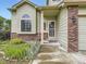 Inviting front entrance showcasing a well-kept lawn, brick accents, and the house number at 4267 Ashcroft Ave, Castle Rock, CO 80104