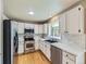 Modern kitchen with white cabinets, stainless steel appliances, and a sleek backsplash at 4267 Ashcroft Ave, Castle Rock, CO 80104