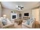 Cozy living room with a white brick fireplace, comfortable seating, and a ceiling fan for enhanced comfort at 4267 Ashcroft Ave, Castle Rock, CO 80104