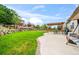 Expansive backyard featuring a patio with pergola, lush lawn, landscaping, and a rock wall at 15635 Dawson Creek Dr, Monument, CO 80132