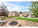 Spacious backyard with a fire pit area, lush lawn, and patio under a wood pergola at 15635 Dawson Creek Dr, Monument, CO 80132