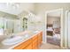 Elegant bathroom with a double vanity, a glass-enclosed shower, and a doorway that leads to a spacious bedroom at 15635 Dawson Creek Dr, Monument, CO 80132