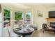 Cozy dining area features a round table, fireplace, and bright natural light from the bay window at 15635 Dawson Creek Dr, Monument, CO 80132