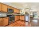 Open concept kitchen features stainless appliances, wooden cabinets, and hardwood floors at 15635 Dawson Creek Dr, Monument, CO 80132