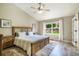 Light filled main bedroom with a vaulted ceiling, wood floors, and window views of the backyard at 15635 Dawson Creek Dr, Monument, CO 80132