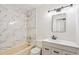 Elegant bathroom features marble-look tile, a modern vanity, and updated fixtures at 1336 Sable Blvd, Aurora, CO 80011