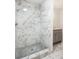Walk-in shower with marble tile and modern bathroom fixtures at 1336 Sable Blvd, Aurora, CO 80011