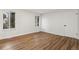 Light-filled bedroom with wood-look floors, two windows, and a door leading to other areas at 1336 Sable Blvd, Aurora, CO 80011