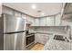 Modern kitchen with stainless steel appliances, granite counters, and stylish tile backsplash at 1336 Sable Blvd, Aurora, CO 80011