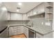 Updated kitchen with stainless appliances, gray cabinets, granite countertops, and unique backsplash at 1336 Sable Blvd, Aurora, CO 80011