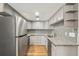 Galley kitchen featuring stainless steel appliances, stylish gray cabinets, and updated countertops at 1336 Sable Blvd, Aurora, CO 80011