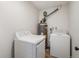 Functional laundry room with a washer, dryer, and a modern hot water tank at 1336 Sable Blvd, Aurora, CO 80011