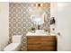 Powder room featuring patterned accent wall, modern sink, and stylish lighting at 1590 Little Raven St # 702, Denver, CO 80202