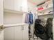 Well-organized laundry room with modern appliances, custom cabinetry, and stylish patterned tile flooring at 1590 Little Raven St # 702, Denver, CO 80202