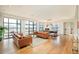 Spacious living area with large windows, hardwood floors, comfortable seating, and a dining area at 1590 Little Raven St # 702, Denver, CO 80202