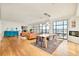 Open-concept living room and dining area with city views, hardwood floors, and fireplace at 1590 Little Raven St # 702, Denver, CO 80202