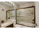 Bathroom featuring a shower-tub with glass doors and granite vanity sink top at 1885 S Quebec Way # H15, Denver, CO 80231