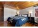 Cozy bedroom with hardwood floors, blue quilt, wood ceilings, and ample natural light at 1400 E Bates Ave, Englewood, CO 80113