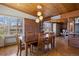 Dining room with wood table, modern lighting, brick accent wall and access to the kitchen at 1400 E Bates Ave, Englewood, CO 80113