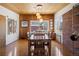 Bright dining room featuring wood floors, wood ceilings, a brick accent wall, and modern light fixture at 1400 E Bates Ave, Englewood, CO 80113