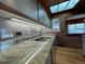 Spacious kitchen with granite countertops, stainless steel appliances, and a skylight, creating a bright, open space at 1400 E Bates Ave, Englewood, CO 80113