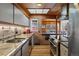Well-lit kitchen featuring granite countertops, stainless steel appliances, and a view into the dining area at 1400 E Bates Ave, Englewood, CO 80113