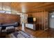 Open-concept living room featuring wood ceilings, brick accent wall, stylish furnishings and hardwood floors at 1400 E Bates Ave, Englewood, CO 80113