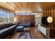 Living room featuring brick wall, hardwood floors, wood ceilings, and modern furnishings at 1400 E Bates Ave, Englewood, CO 80113