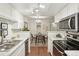 Efficient kitchen layout flowing into the dining area with stainless steel appliances and white cabinetry at 8335 Fairmount Dr # 5-106, Denver, CO 80247