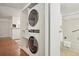 Convenient, in-unit laundry setup with stacked washer and dryer, storage shelves, and proximity to the bathroom at 8335 Fairmount Dr # 5-106, Denver, CO 80247