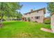 Large backyard with lush green lawn and mature trees at 7700 E Oxford Ave, Denver, CO 80237