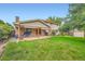 Expansive backyard with mature trees and a covered patio at 7700 E Oxford Ave, Denver, CO 80237
