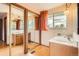 Bright bathroom featuring wood vanity with dual sinks and mirrors, a window and decorative light fixtures at 7700 E Oxford Ave, Denver, CO 80237