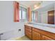 Bathroom features a single vanity with a large mirror and a shower/bath combination at 7700 E Oxford Ave, Denver, CO 80237