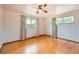 Bright bedroom with hardwood floors, white walls, two windows and a ceiling fan at 7700 E Oxford Ave, Denver, CO 80237