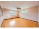 Spacious bedroom featuring gleaming hardwood floors, neutral walls, two windows and a ceiling fan at 7700 E Oxford Ave, Denver, CO 80237