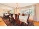 Traditional dining room featuring a large table, chairs, chandelier, and hardwood flooring at 7700 E Oxford Ave, Denver, CO 80237