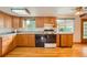 Well-lit kitchen featuring wooden cabinetry, a double sink, and black appliances at 7700 E Oxford Ave, Denver, CO 80237