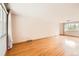 Spacious living room featuring gleaming hardwood floors, a large window, and neutral walls at 7700 E Oxford Ave, Denver, CO 80237