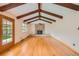 Bright living room with hardwood floors, exposed wood beams, and a brick fireplace at 7700 E Oxford Ave, Denver, CO 80237