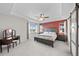 Comfortable main bedroom with a tray ceiling, fan, windows, and wood-look sliding barn door at 2464 Garganey Dr, Castle Rock, CO 80104