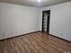 An empty bedroom with wood-look floors and a view into the closet at 7665 E Eastman Ave # 104A, Denver, CO 80231
