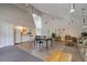 Open concept kitchen, dining, and living room with vaulted ceilings and modern lighting fixtures at 7665 E Eastman Ave # 104A, Denver, CO 80231