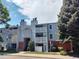 Exterior view of condo building with balconies, red brick and gray siding at 7665 E Eastman Ave # 104A, Denver, CO 80231